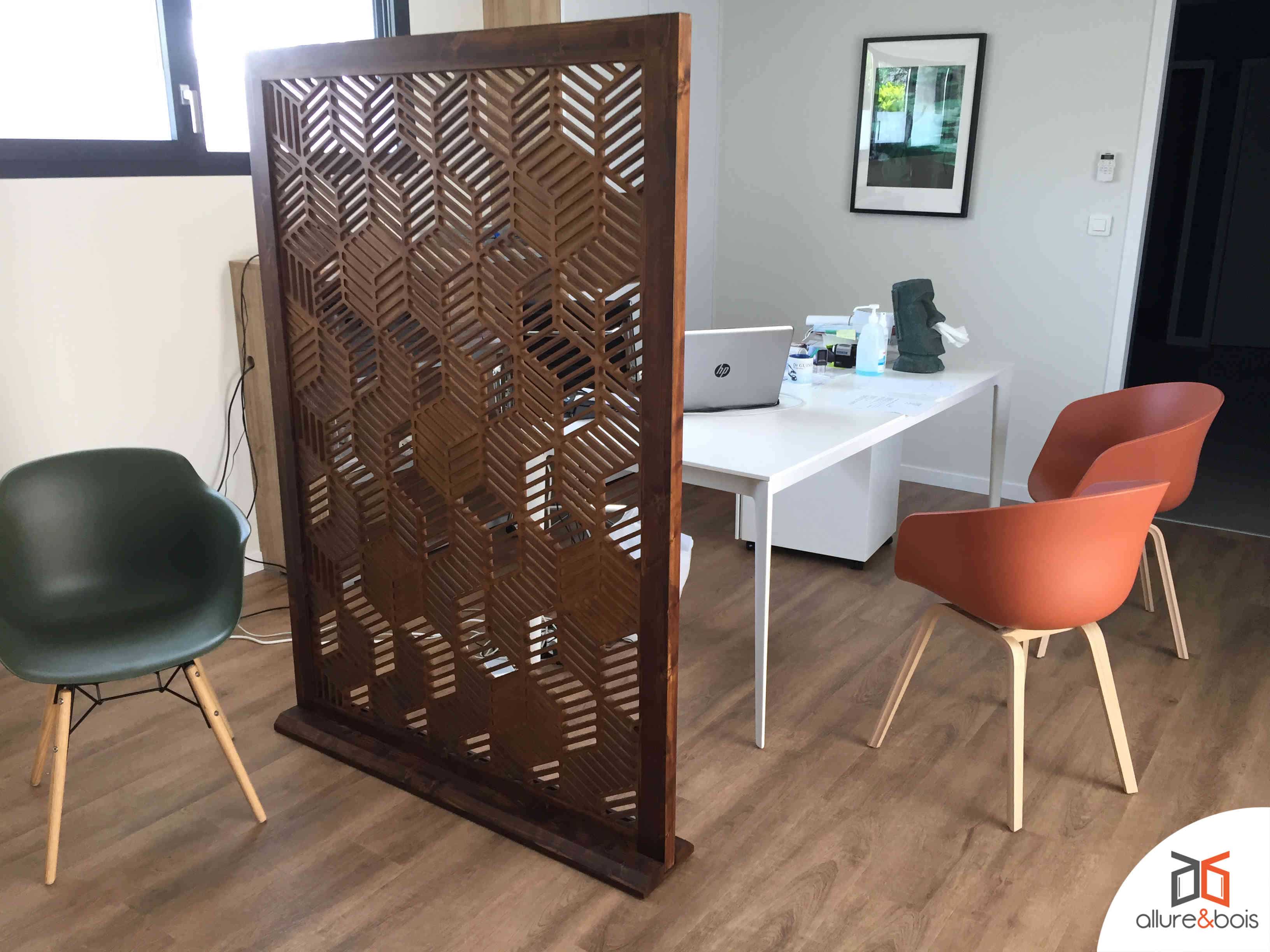 Panneau ajouré en bois pour séparer salle à manger et salon.